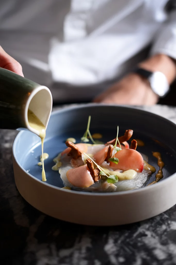 À retrouver au menu de l'Auberge de Dardagny :  Carpaccio de féras, girolles marinées, pêches de vigne, sauce au poivre vert.